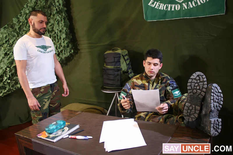 Two adult men in casual military clothing indoors