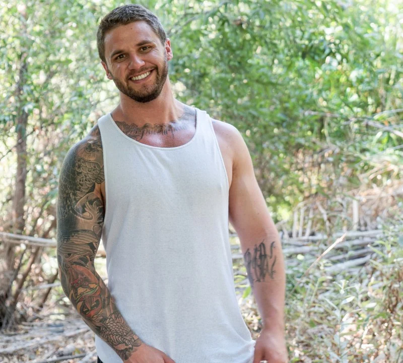 Adult model wearing a white tank top outdoors