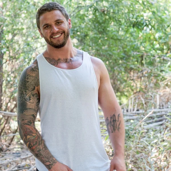 Adult model wearing a white tank top outdoors