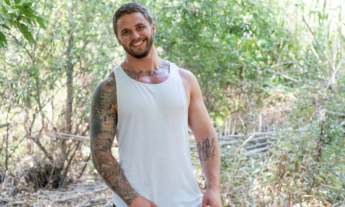 Adult model wearing a white tank top outdoors