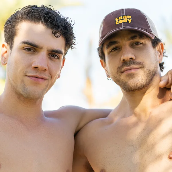Two shirtless Sean Cody models flexing their biceps poolside in Sean Cody briefs and a jockstrap