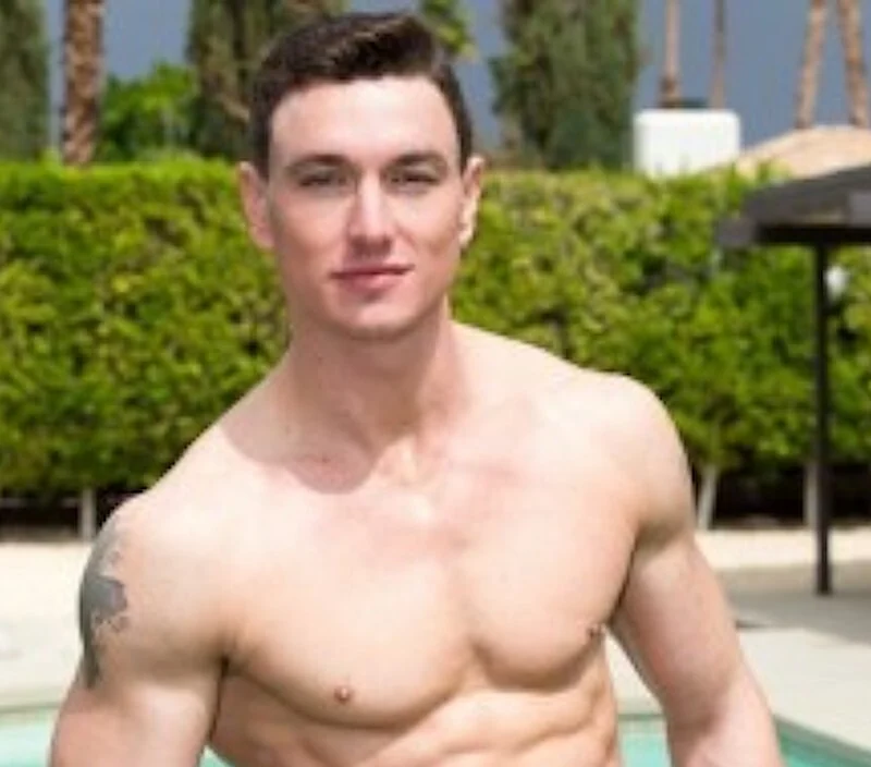 Adult model Cade Maddox beside a swimming pool, shirtless